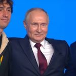 Putin in posa, con un braccio sulla spalla di Jorit (alla sua destra). Alla sinistra un altro giovane partecipante all'evento di Sochi