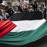 Manifestanti con la bandiera della Palestina srotolata. Il dibattito sul riconoscimento di uno Stato palestinese è tornato d'attualità.