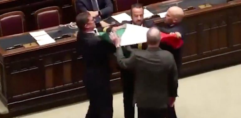Il deputato del M5S Donno viene fermato dai funzionari della Camera mentre mostra il tricolore al ministro Calderoli durante la discussione del disegno di legge sull'autonomia differenziata