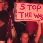 Una donna con un cartello con la scritta "Stop the war" in una manifestazione in Israele per chiedere il cessate il fuoco a Gaza.