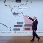 Due conduttori in uno studio televisivo mostrano sulla mappa l'area nel Kursk in Russia occupata dalle forze militari ucraine.