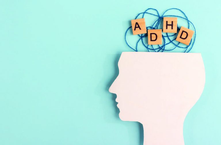 Il profilo di un volto umano aperto dall'alto e sopra dei fili intrecciati con la scritta ADHD