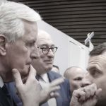 Barnier e Macron si guardano l'un altro (alle spalle si intravedono alcune persone)