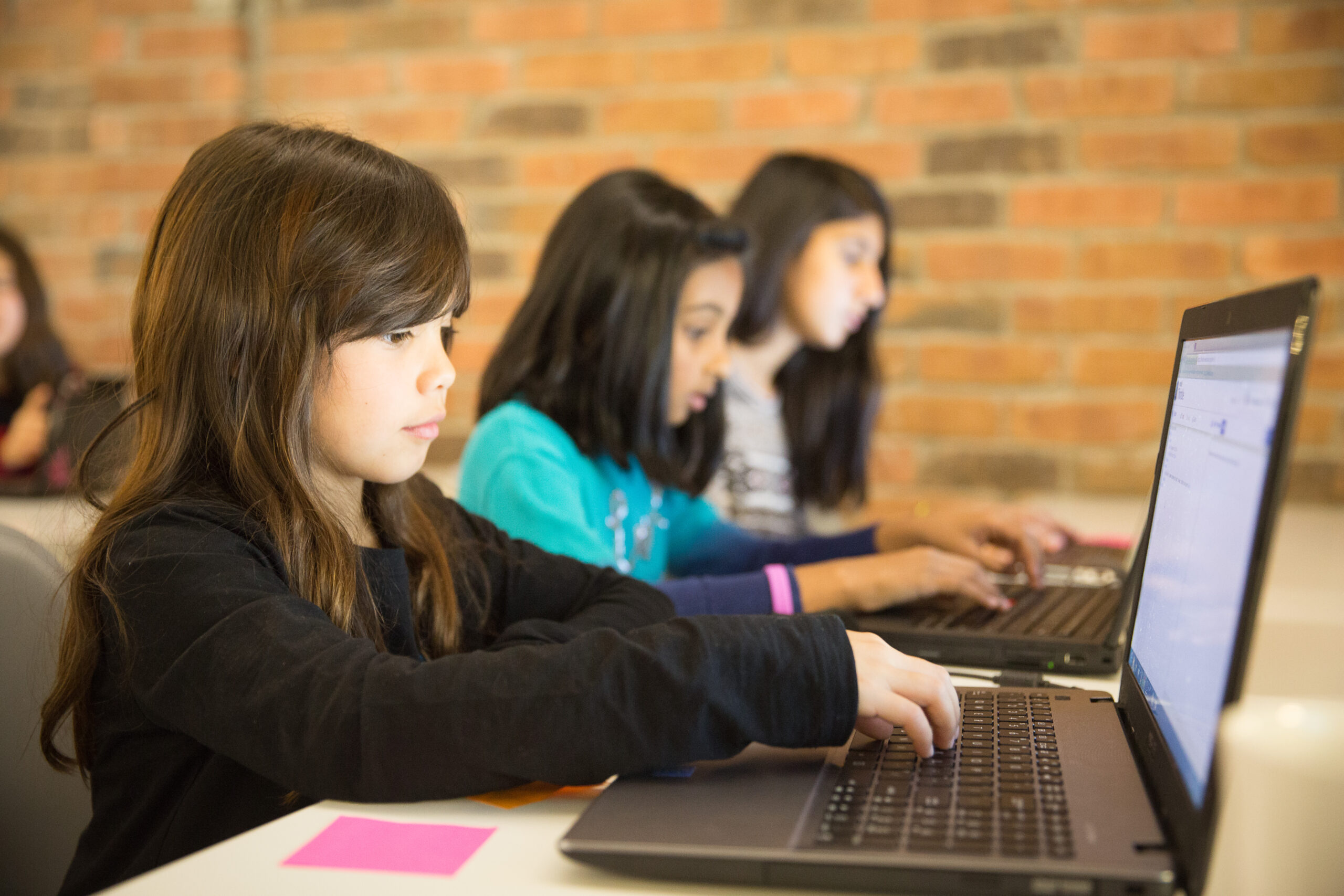 Alcuni bambini a scuola davanti a un computer. Se tanto si tiene a una scuola di qualità, che sia promotrice di uno sviluppo adeguato dei cittadini e delle cittadine del domani, perché non lasciar perdere le misure furbe e banalmente propagandistiche, come quella del divieto tout court del cellulare,  e lavorare seriamente per mettere nella migliore condizione di lavoro, riconoscendone la piena autonomia ma anche il grande valore sociale e culturale anche attraverso risorse economiche non vergognose, adeguate e decenti e percorsi formativi seri e aggiornati proprio questi protagonisti centrali della formazione oggi, cioè il quasi milione di docenti della scuola italiana?