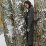 Una donna in piedi in mezzo a un gruppo di quattro alberi, in un paesaggio innevato. È la copertina del libro di Francesca Melandri che fa riflettere sulla guerra in Ucraina.