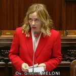 La presidente del Consiglio Giorgia Meloni vestita di rosso mentre parla in parlamento per presentare la manovra finanziaria