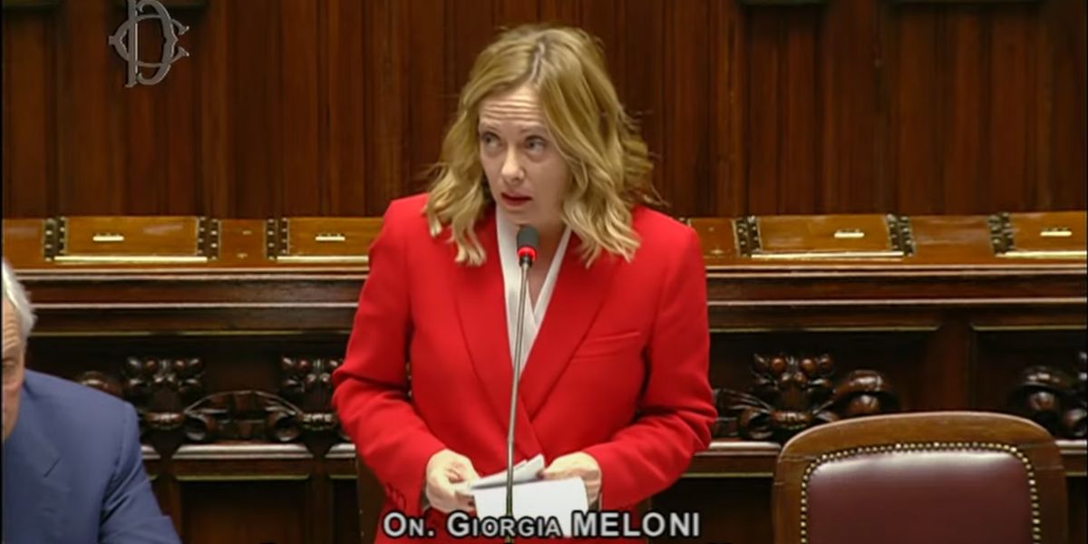 La presidente del Consiglio Giorgia Meloni vestita di rosso mentre parla in parlamento per presentare la manovra finanziaria