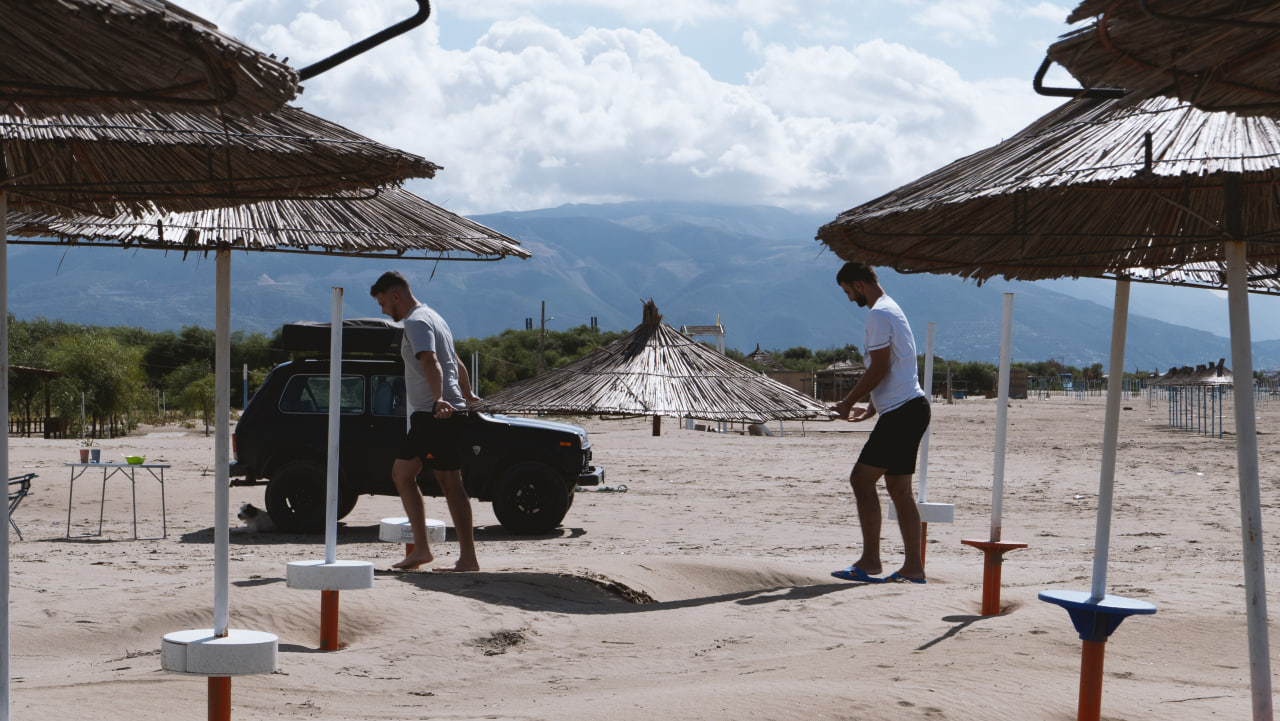 Due persone passeggiano su una spiaggia di Valona in Albania