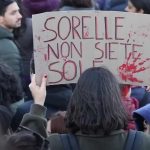 Una donna con un cartello con la scritta "Sorelle non siete sole" in occasione della manifestazione per la giornata internazionale per eliminare la violenza contro le donne