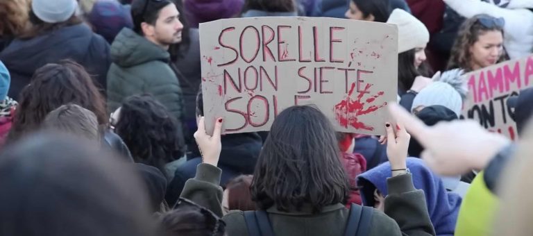 Una donna con un cartello con la scritta "Sorelle non siete sole" in occasione della manifestazione per la giornata internazionale per eliminare la violenza contro le donne