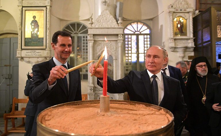 Il presidente della Russia Vladimir Putin e l'ex capo del regime in Siria Assad accendono una candela insieme da un cero.