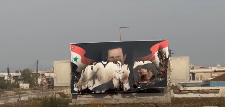 Un cartellone stradale in Siria con l'immagine di Assad strappata