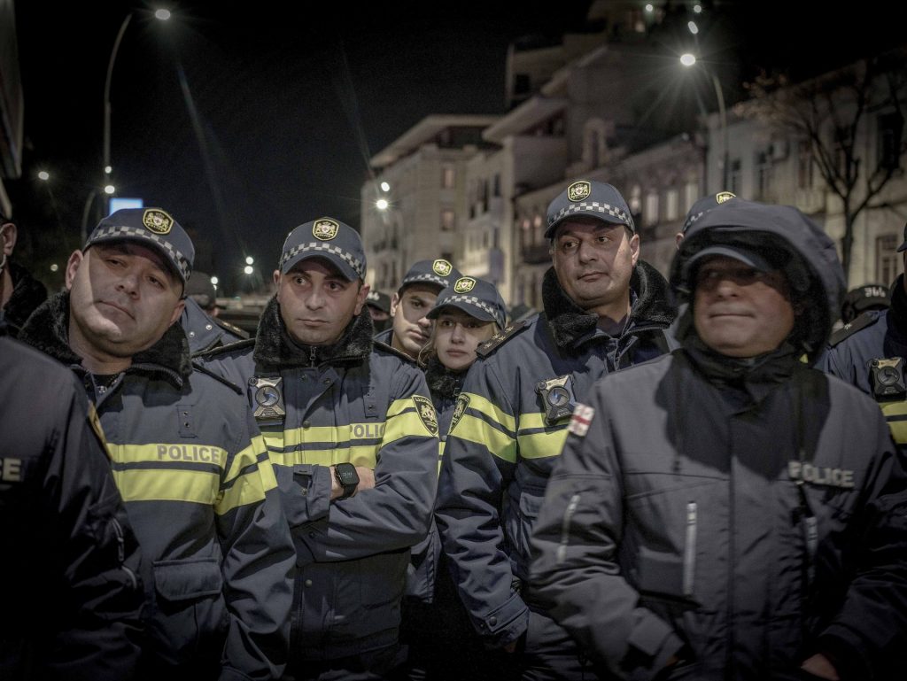 Un gruppo di poliziotti uomini con al centro una poliziotta.