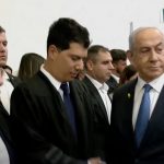 Il primo ministro israeliano Netanyahu stringe la mano al suo avvocato difensore poco prima di iniziare la sua udienza in tribunale nel processo che lo vede coinvolto.