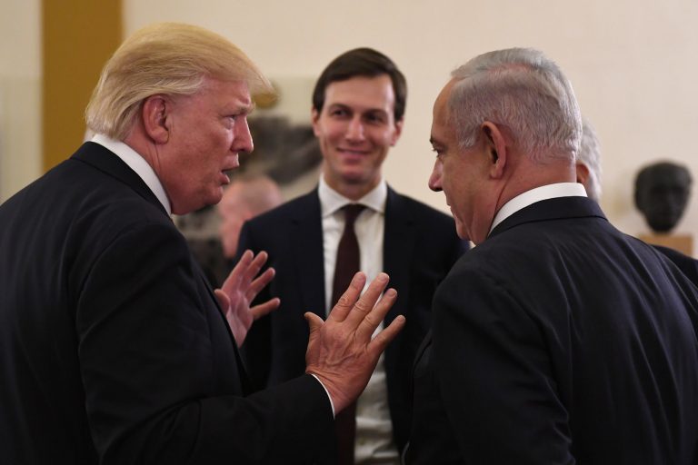 Trump, di spalle, parla a mani aperte con Netanyahu durante una sua visita in Israele.