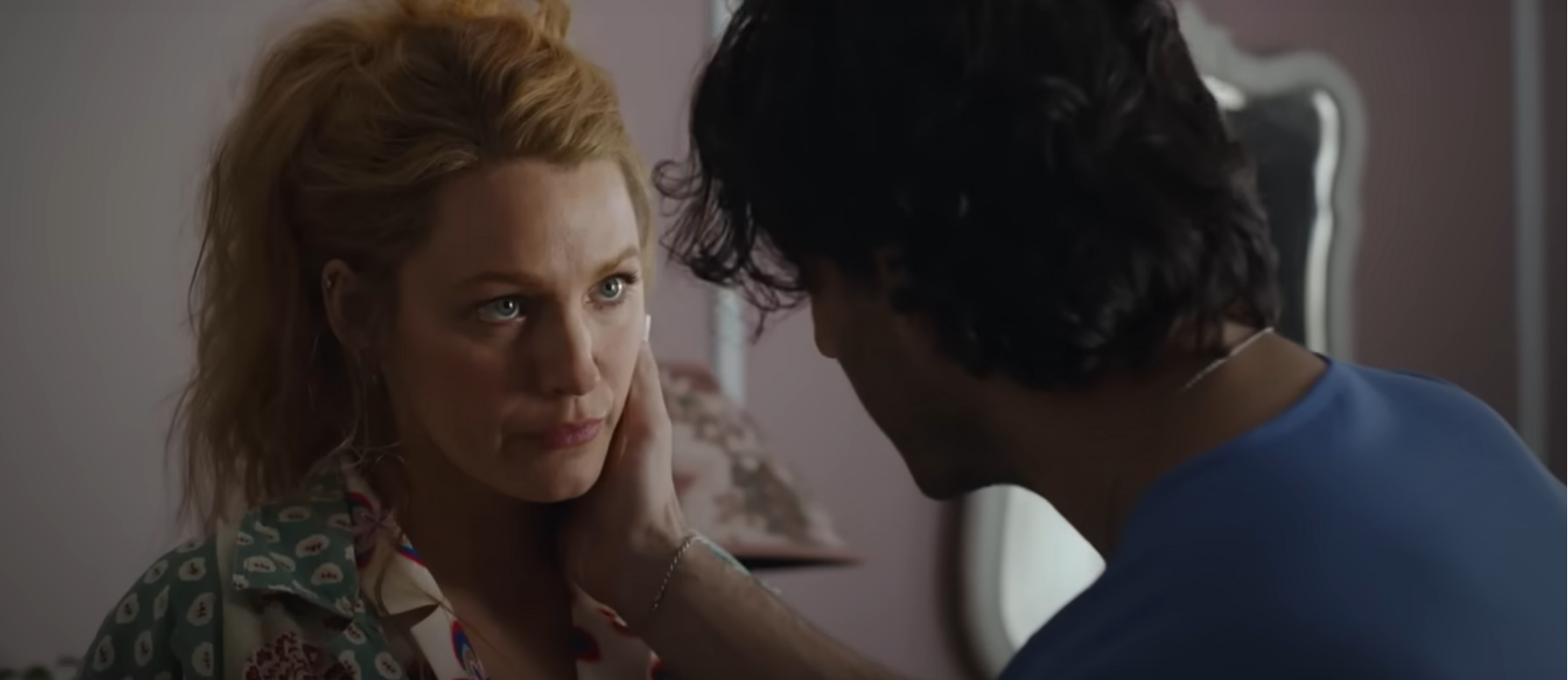 Blake Lively e Justin Baldoni in una scena di "It end with us": Lui di spalle ha la mano destra appoggiata sul collo di lei. Lei lo guarda