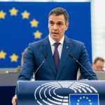 Il primo ministro della Spagna, Pedro Sánchez, durante un intervento al Parlamento Europeo. Sullo sfondo c'è una bandiera dell'Unione Europea.