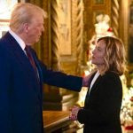 Donald Trump guarda Giorgia Meloni e le poggia una mano sulla spalla destra durante l'incontro improvviso a Mar a Lago, in Florida.