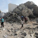 Abitanti di Gaza si muovono tra le macerie dopo gli attacchi israeliani iniziati nell'ottobre 2023