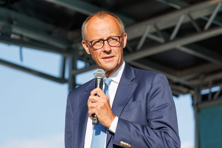 Friedrich Merz con il microfono in mano durante un comizio