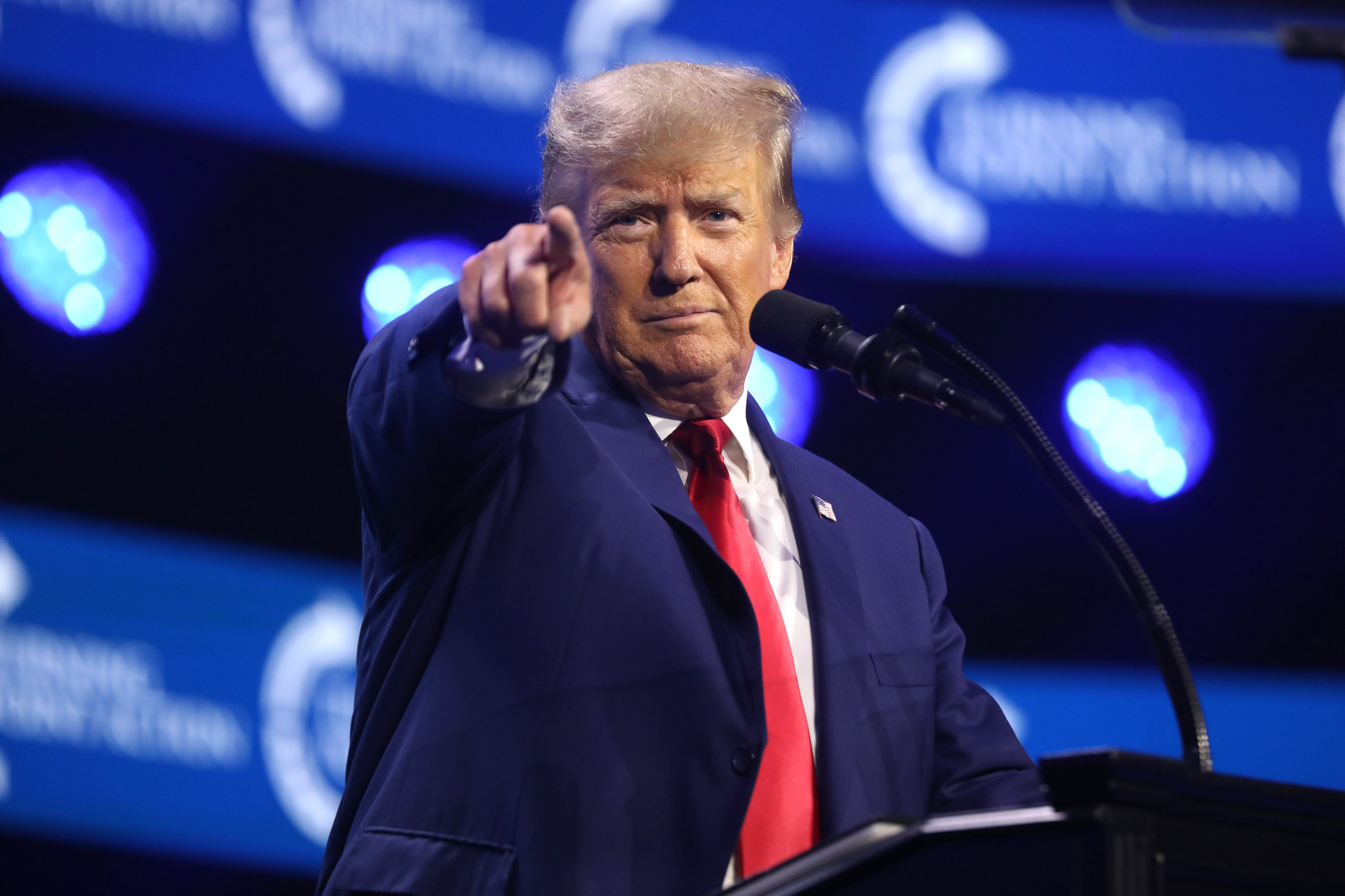 Trump fotografato di fronte punta l'indice verso la fotocamera