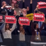 M5S MEPs raising signs (“no more weapons, ‘no rearmEU’, + healthcare - weapons”)